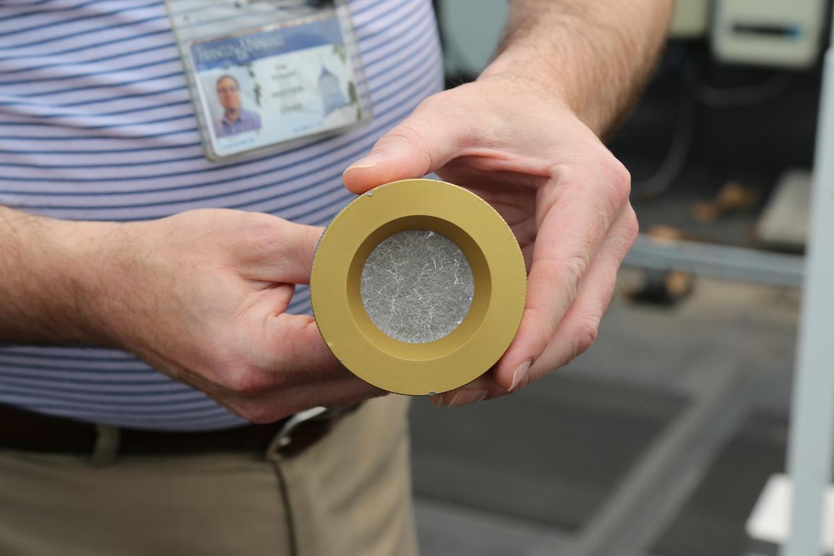 Local scientist Eric Schwarz shows a glass fiber filter placed in a monitor on the roof of ASFC on the evening of July 16. By the afternoon of July 17, the white-colored filter was coated in debris.