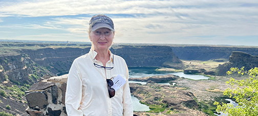 A photo of Dorothy Merritts standing in front of a reservoir. 