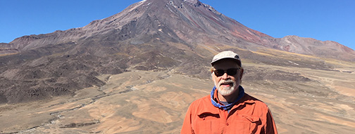 A photo of Andy de Wet in front of barren mountains in the Andes. 