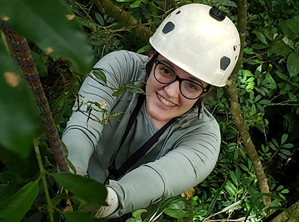 Hannah Connuck wearing a helmet high in a jungle