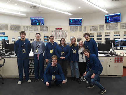 James Strick and a group of students stand inside a control room