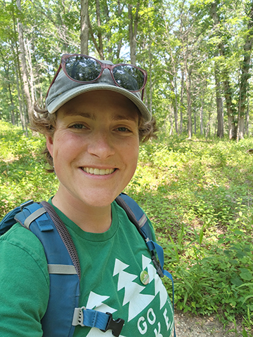 A photo of Emily Wilson standing in a forest