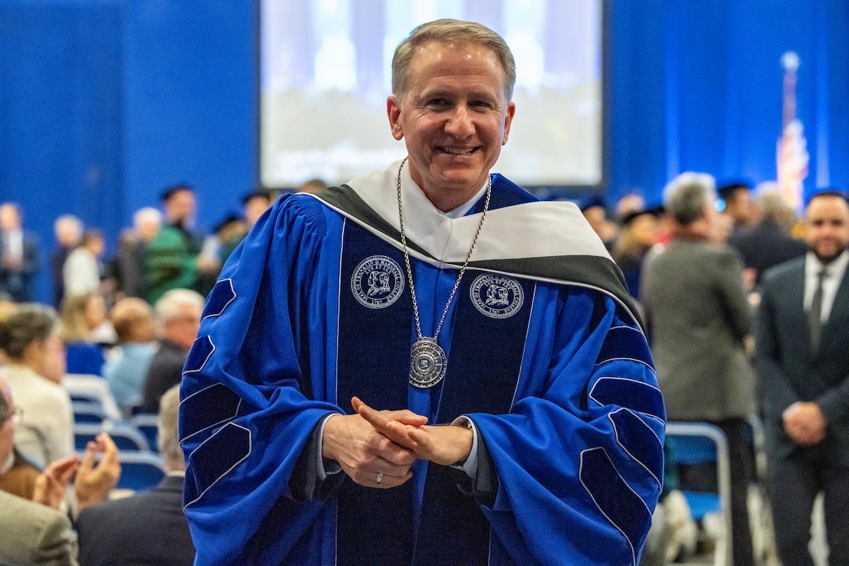President Rich, wearing the presidential medallion, greets ceremony visitors. (Photo by Deb Grove)