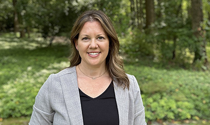 A photo of Jessica Keech standing in front of trees.
