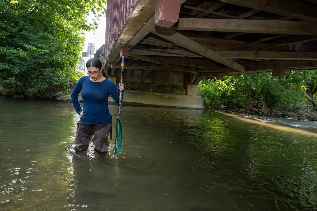Roselyn Ovalles collects water samples.