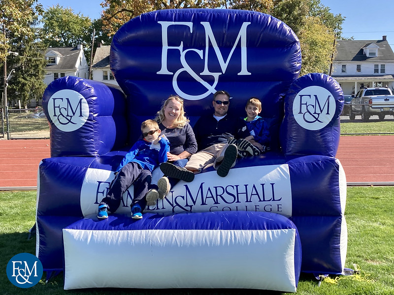 Family of three plays cornhole on Williamson Field.