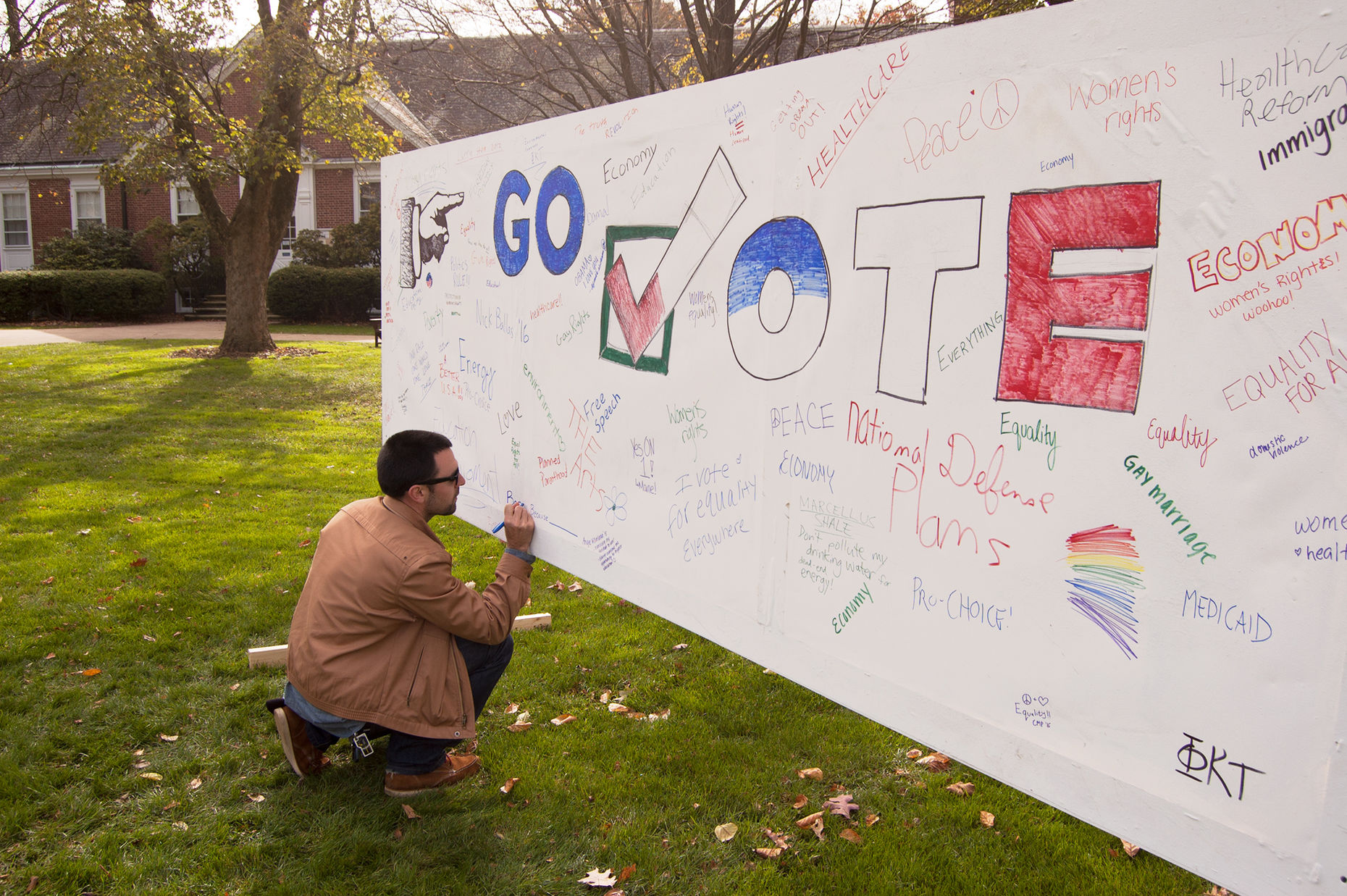 F&M student signs a banner on Hartman Green