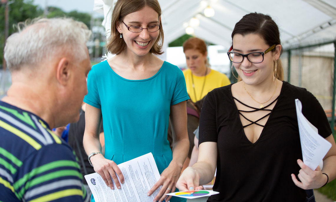 Assistant Professor of Spanish and Linguistics Jessica Cox and sophomore Lilian Rodriguez talk with an attendee of the 35th annual San Juan Bautista Hispanic Festival.