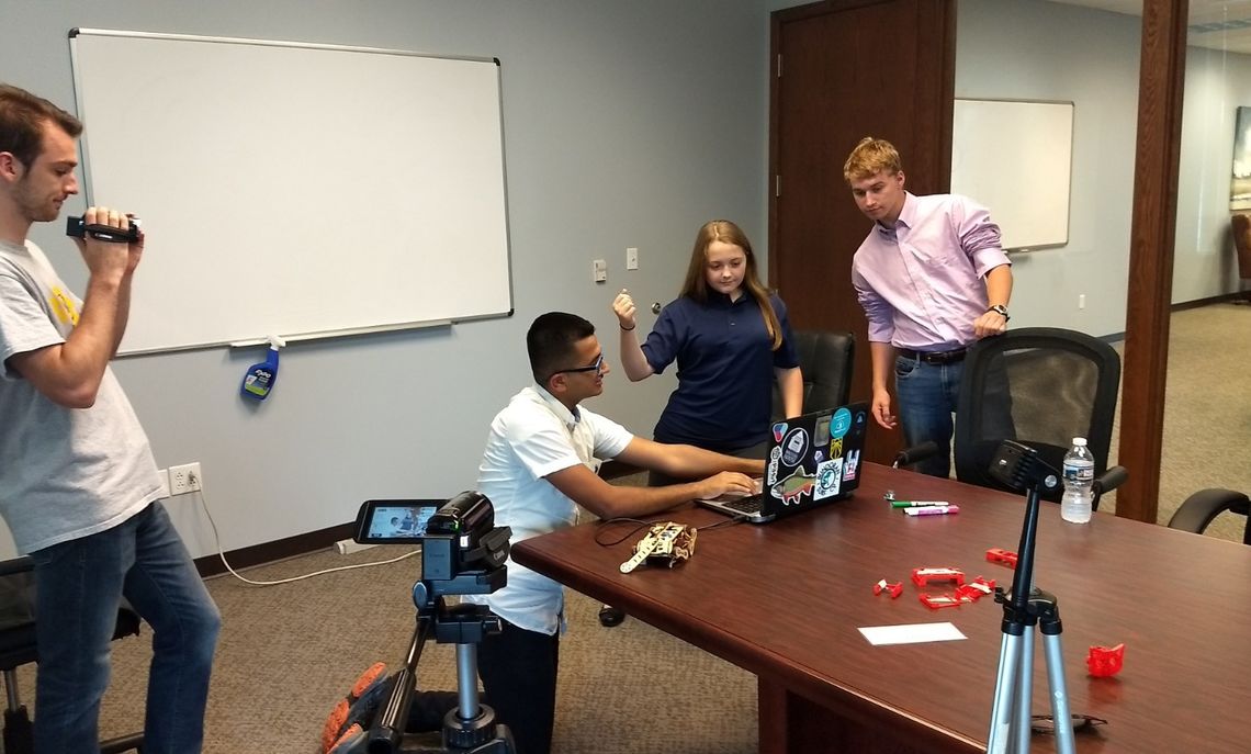 Randhawa downloads for the cat robot the arm and elbow actions of the two students that the third  student video records for the downloads.