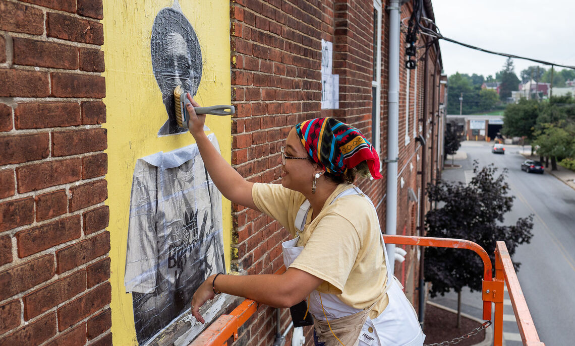 Salina Almanzar ’13, photography technician at F&M, was hired to paint a mural in a Lancaster neighborhood.