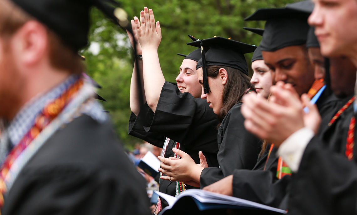 Twin sisters Emily and Livia Meneghin cheer on their fellow graduates lining up for their diplomas.