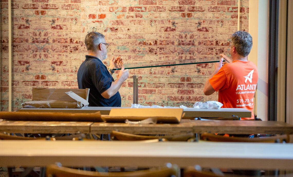 A crew works on installing the faux brick walls in the dining hall.