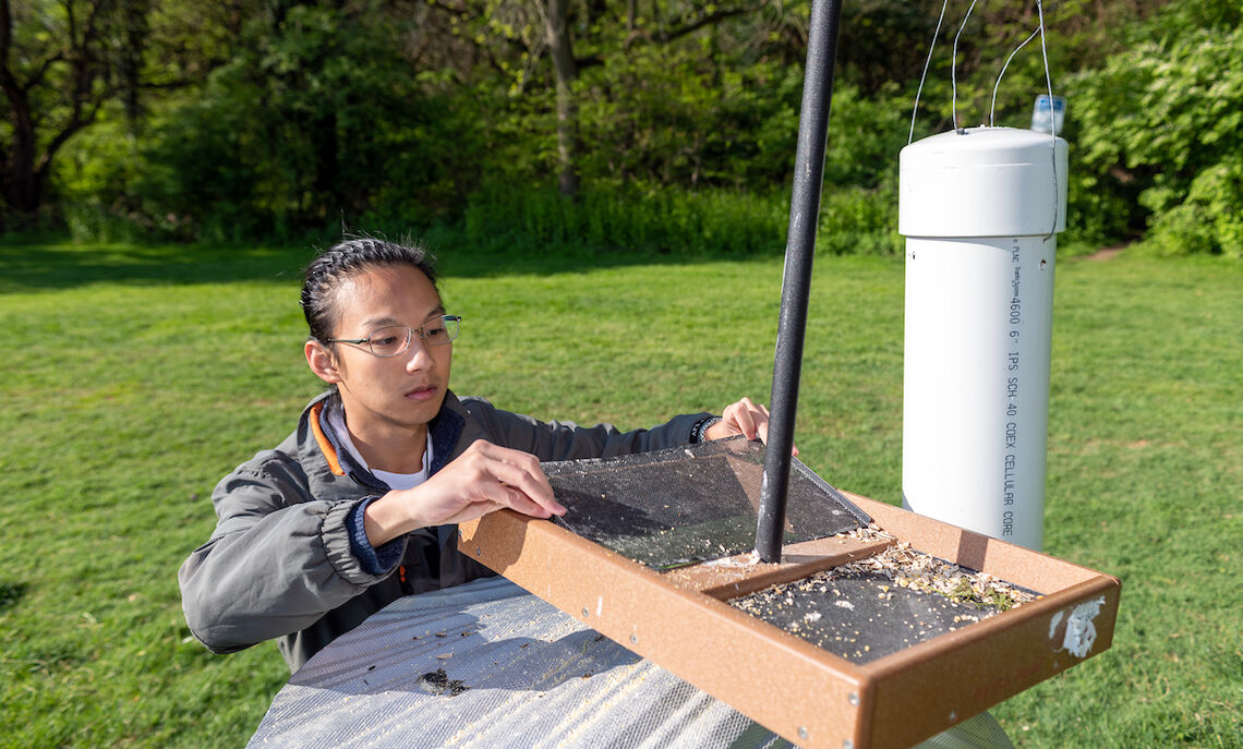 William Li '23 refills bird feeders at Baker Campus.