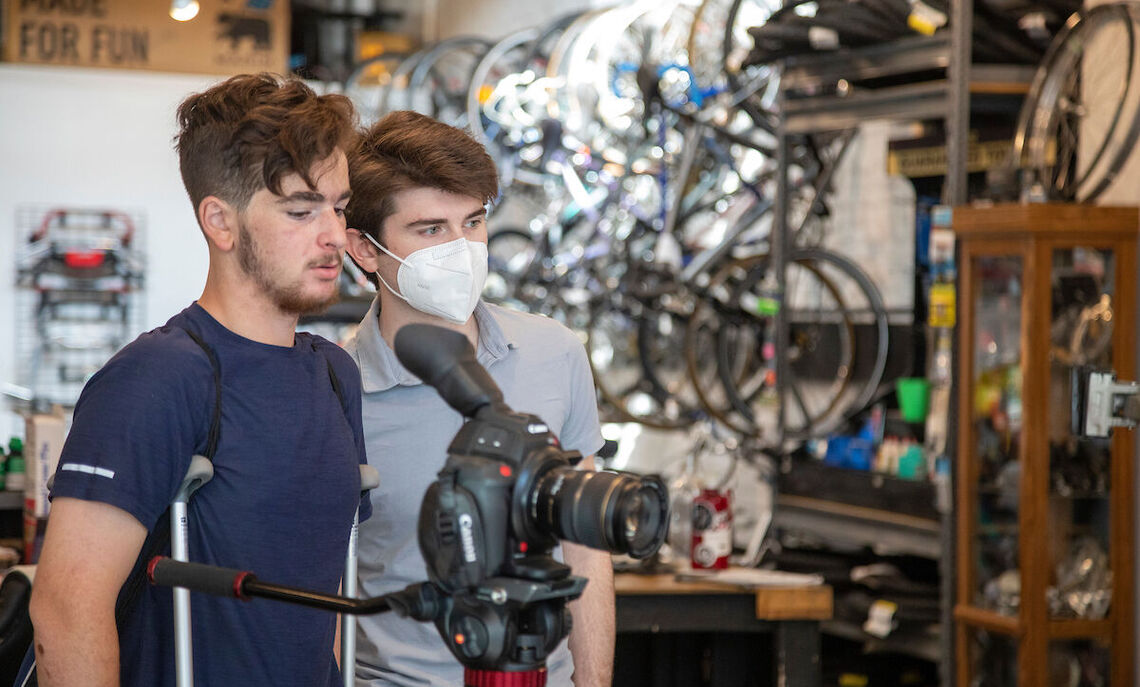 Simon Taylor, right, helps his high school mentee prepare a shot.