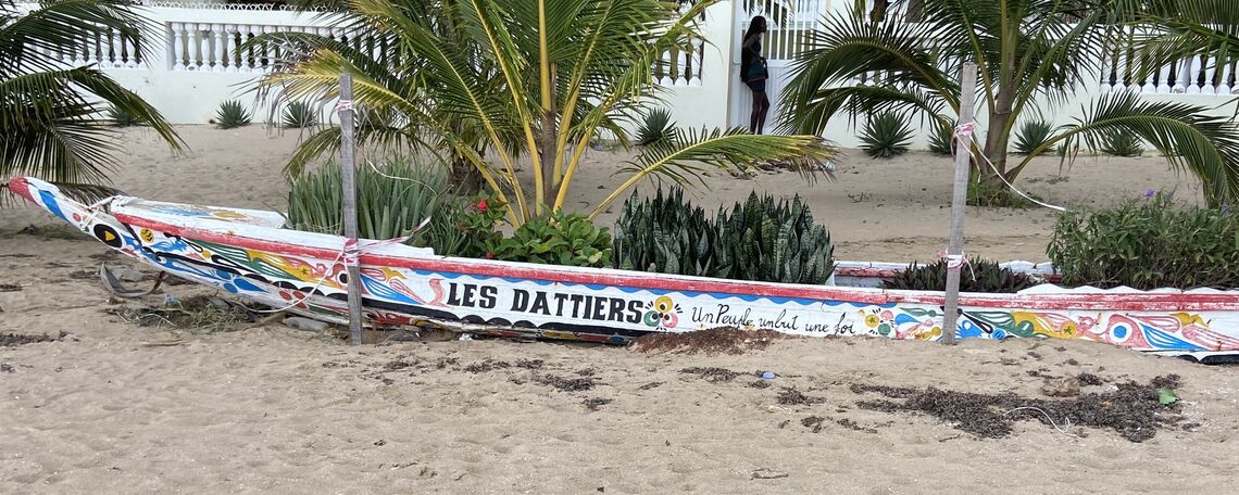 A home along the beach with a boat that shares Senegal’s motto, “Un peuple un but une foi” (one community, one goal, one faith).