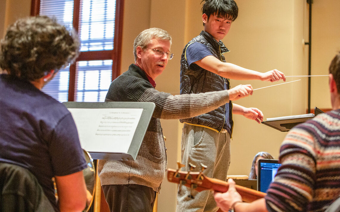 Brian Norcross works with students in his conducting class.