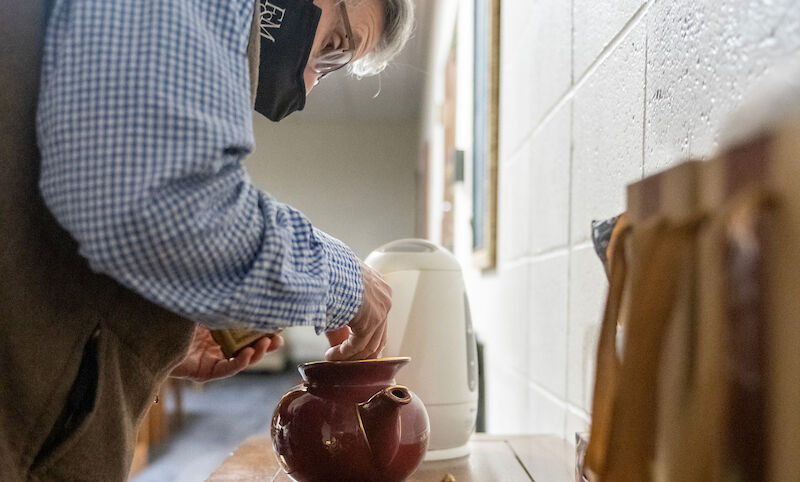 Richard Kent, professor of art history, prepares hot tea following a student meditation session.