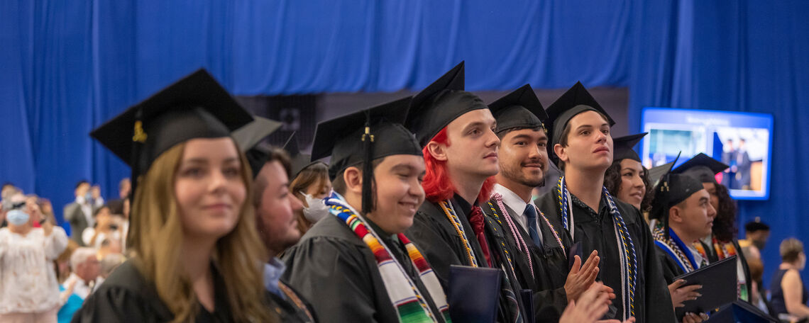 Happy seniors applaud their classmates during the degree-conferring portion of the program at Commencement 2022.
