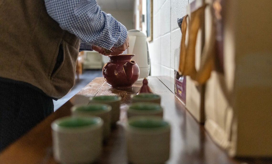 Richard Kent, professor of art history, prepares hot tea following a student meditation session.