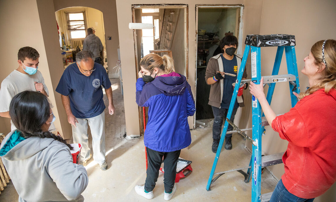 Adviser Andy Gulati (blue shirt) examines the floor with students.