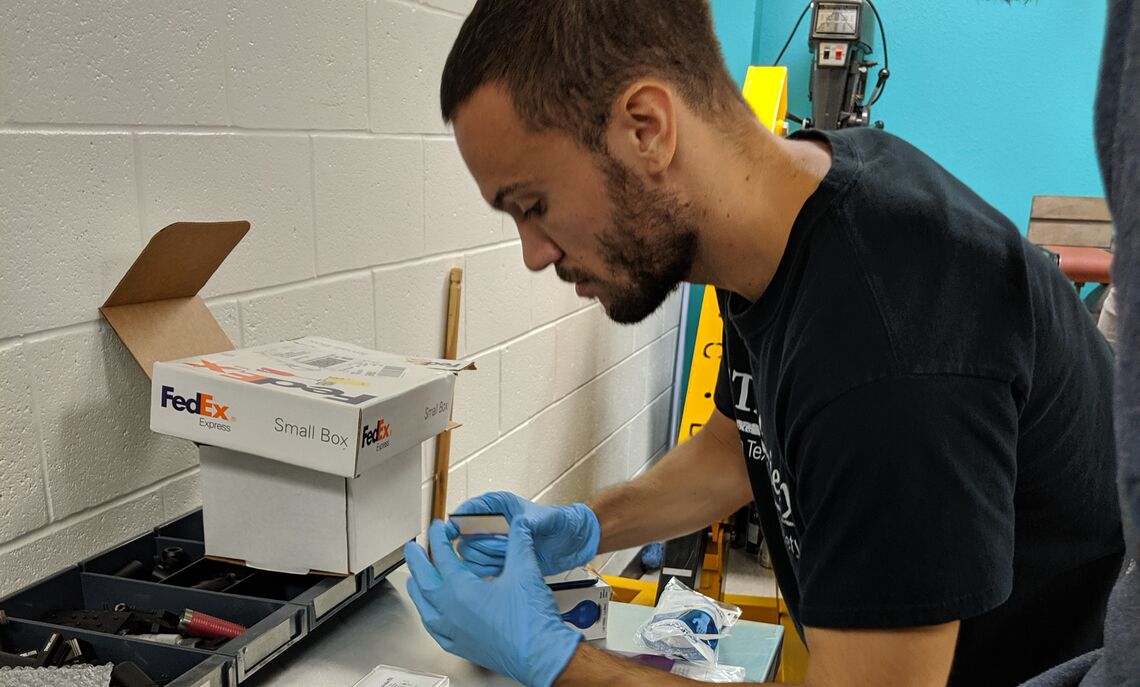 Camuccio with colleagues in an optics lab installing photometric filters into a CCD camera for a telescope