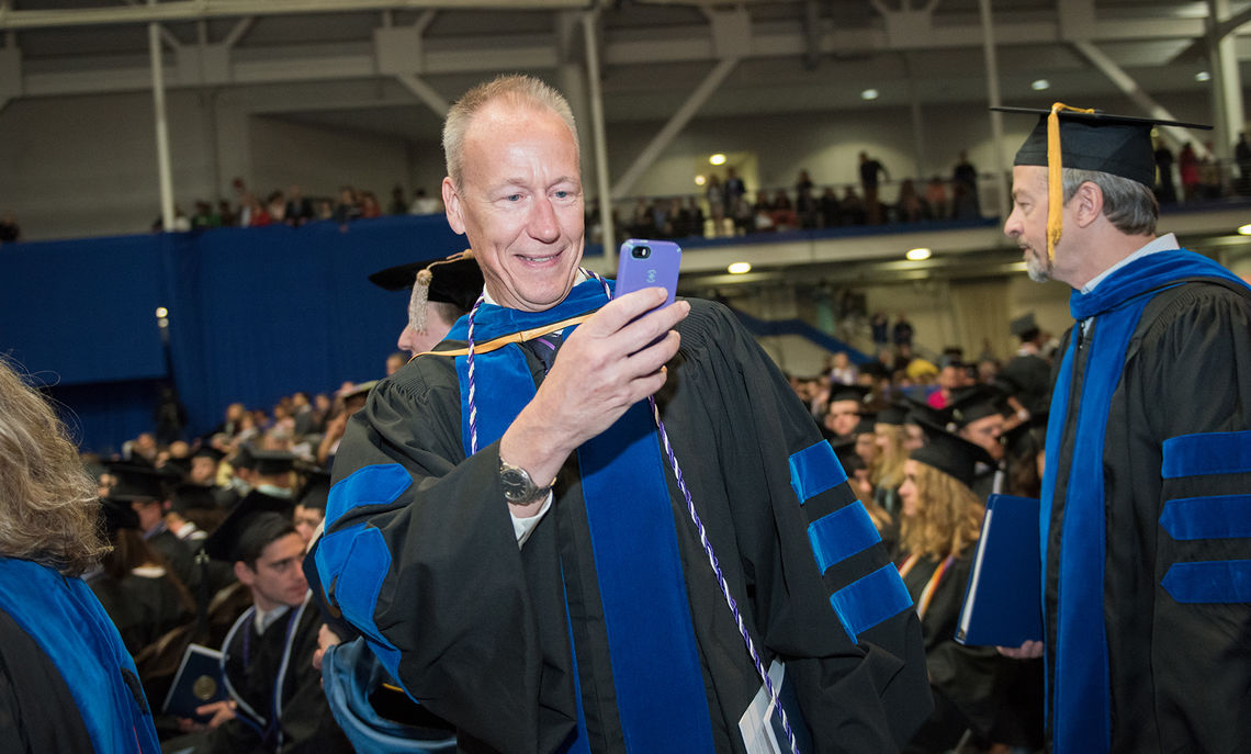 Dean Hammer, The John W. Wetzel Professor of Classics and Professor of Government and don of New College House, captures a photo of some graduating seniors.