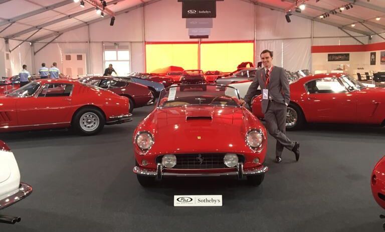 Greg Duckloe '13 posing with a Ferrari 250 Short Wheelbase California Spider during RM Sotheby's auction at the Ferrari factory in Maranello, Italy.