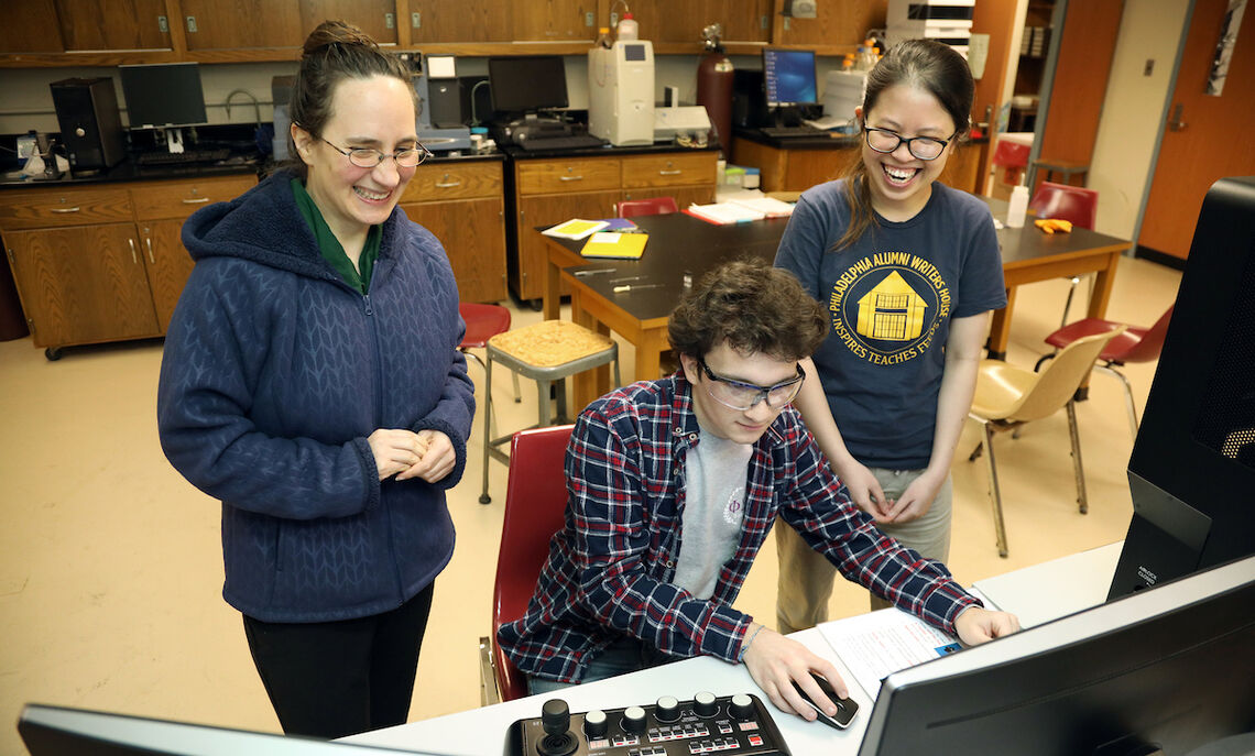 In this 2018 photo, Han Le and fellow chemistry major Angus Unruh work with Professor Kate Plass on the latest computer microscope.