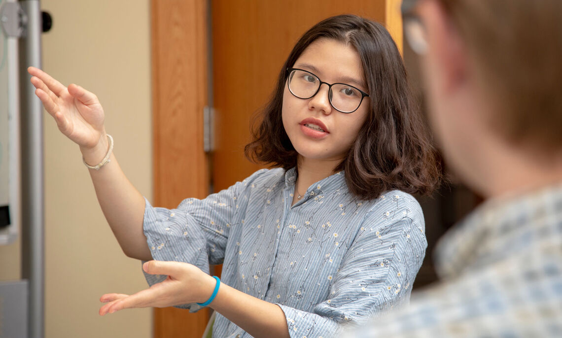 Thu Do '21 describes findings in her research to computer scientist Prof. Ed Novak in his research lab.