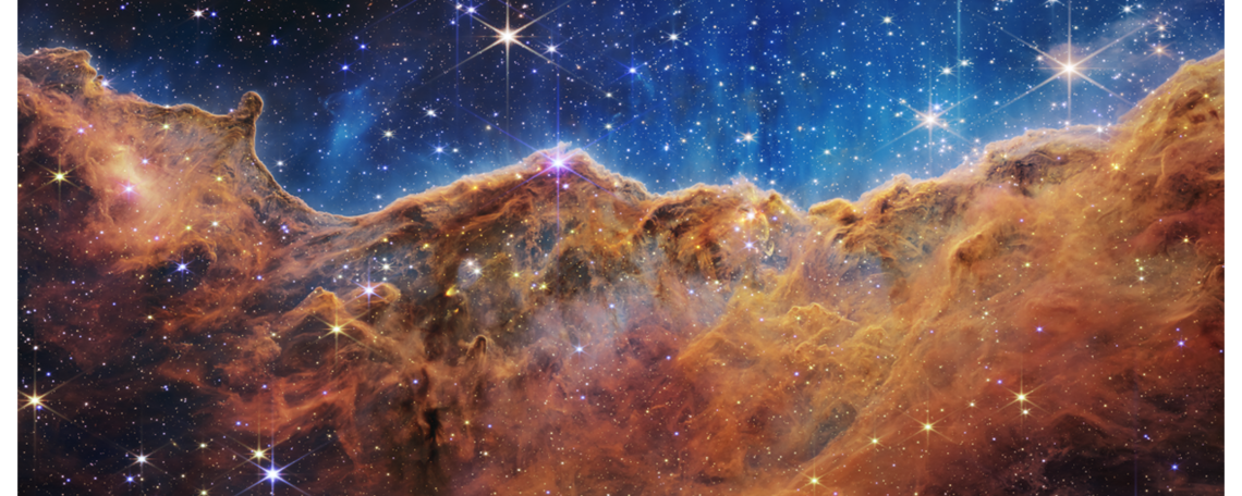 This landscape of “mountains” and “valleys” speckled with glittering stars is actually the edge of a nearby, young, star-forming region called NGC 3324 in the Carina Nebula. Captured in infrared light by NASA’s new James Webb Space Telescope, this image reveals for the first time previously invisible areas of star birth.
