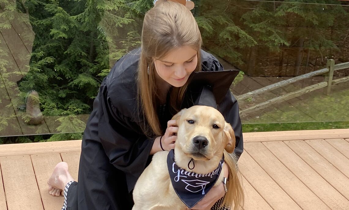 Martha Mumenthaler '21 celebrating her F&M graduation with her service dog, Elvis. Mumenthaler  trained Elvis after her first service dog, Yoda, passed away in 2020.