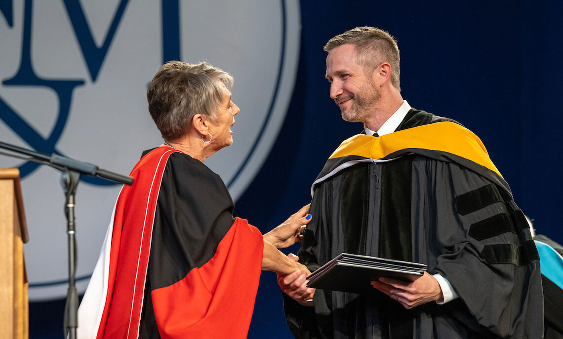 F&M President Barbara Altmann presents an honorary degree to Commencement speaker Jacob Bleacher '00.
