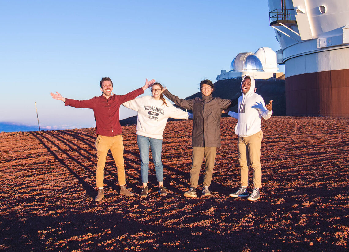 Professor Trainor with seniors Becca McClain and Issac Lin and junior Ojima Abraham atop Hawaii's Mauna Kea to look at the galaxies.