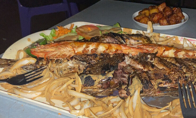 ... A Senegalese platter with grilled fish, shrimp, plantain, and onion sauce enjoyed on the beach.